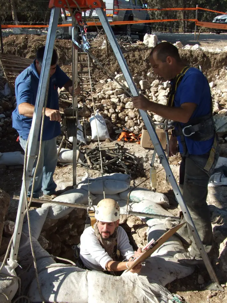 An Israel Antiquities Authority worker goes down into the well. Photographic credit: Yotam Tepper, courtesy of the Israel Antiquities Authority.