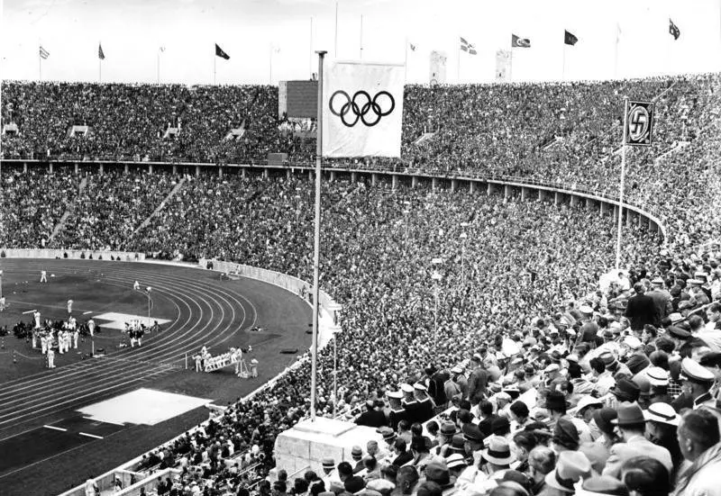 The Olympic Flag flying next to the Personal standard of Adolf Hitler over the Olympic Stadium, Berlin 1936