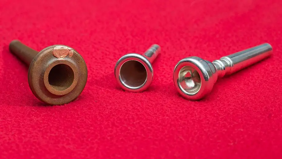 The 3-D printed artifact (left) with mouthpieces of a modern trumpet (right) and french horn. CREDIT : Stuart Hay, ANU
